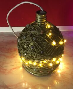 Photo of gold rope twined large bottle shaped light with hanging lamp holder and warm colored faery lights