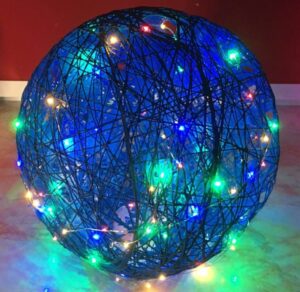 Photo of dark blue yarn globe light with multi color faery lights intertwined with it