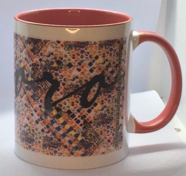 Photo of white ceramic mug with red interior and a colorful print around it