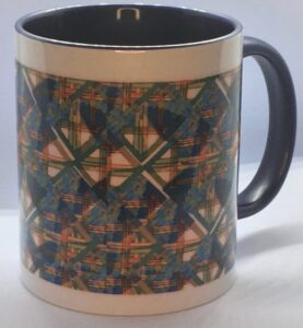 Photo of white ceramic mug with navy blue interior and a colorful print on the exterior