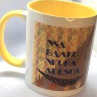 Photo of a white ceramic mug with a yellow interior and handle and a typography design on the exterior