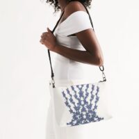 Photo of a lady holding a zip pouch bag with a leather strap handle and a flowery design