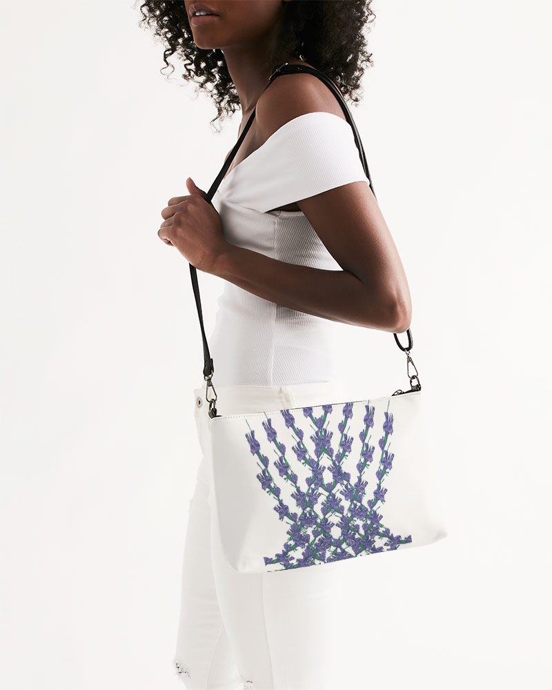 Photo of a lady holding a zip pouch bag with a leather strap handle and a flowery design
