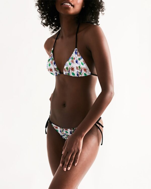 Lady modeling a bikini set with floral and plant based print on it.