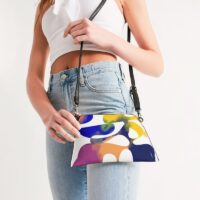 Photo of a lady holding a wristlet bag with an abstract art print on.