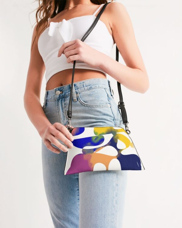 Photo of a lady holding a wristlet bag with an abstract art print on.