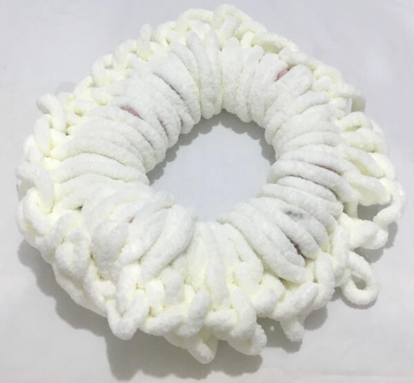 White colored Chunky yarn pillow crocheted into a donut shape.